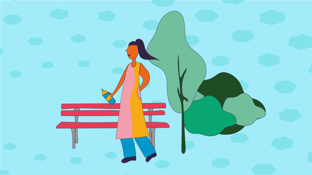 A lady enjoying the outdoors near a bench and trees