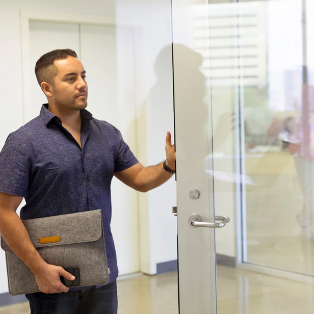 Picture of a surveyor checking a door in an office building.